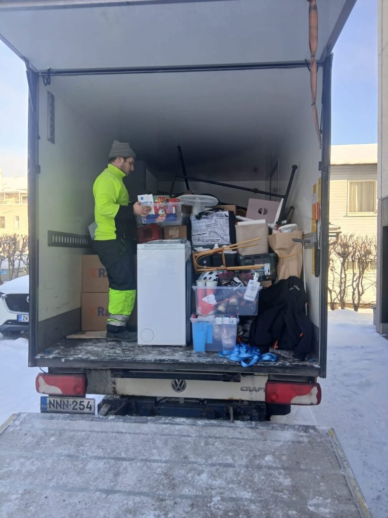 Muuttomiehet kantavat muuttolaatikoita muuttoautoon Porvoossa